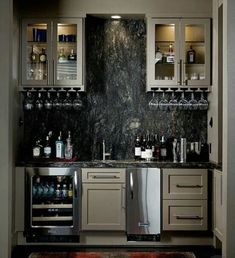 a home bar with wine glasses and liquor bottles on the shelves, along with an area rug