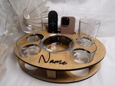 a personalized wooden tray with four glasses and an iphone on it that says name