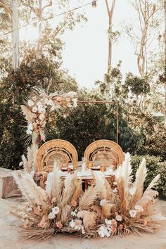 an outdoor table set up with wicker chairs and flowers