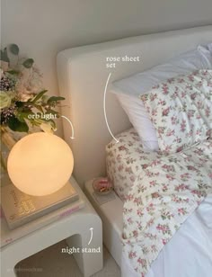 an image of a bedroom setting with bedding and flowers on the side table next to it