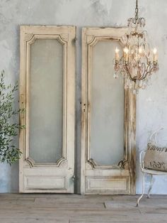 an old pair of doors with chandelier hanging from the ceiling next to it