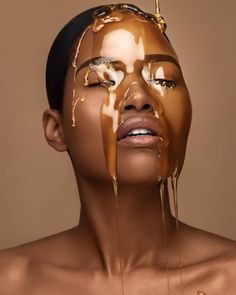 a woman is covered in chocolate and has her face painted with gold paint on it