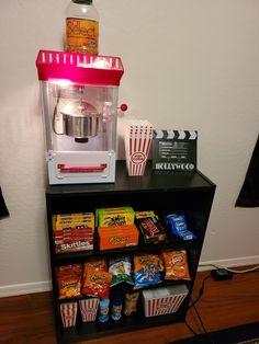 a popcorn machine sitting on top of a shelf filled with snacks