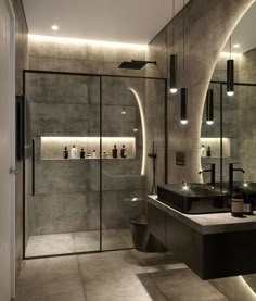 a modern bathroom with two sinks and a shower stall in the middle, surrounded by concrete walls