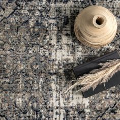 a roll of yarn next to a spool of thread on top of a rug