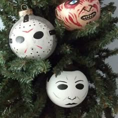 three halloween ornaments hanging from a christmas tree