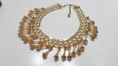 "Vintage gold tone dangling choker necklace. 15\" long including the chain fastener. Band is 3/4\" tall, consisting of smooth & brushed gold tone metal links. Twenty-seven (27) 1\" dangles are all present and intact. Absolutely gorgeous & classic! Unsigned." Gold Dangle Chain Choker, Gold Metal Drop Dangle Necklace, Gold Metal Dangle Choker, Unicorn Pendant, Pearl Pendant Necklace, Choker Necklaces, Pearl Pendant, Gold Tone Metal, Vintage Gold