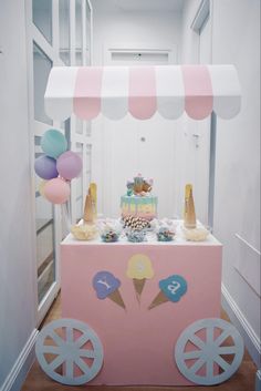 an ice cream cart is decorated with balloons and confetti for a birthday party