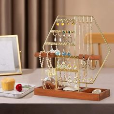 a table with a cupcake and jewelry holder on it, along with other items