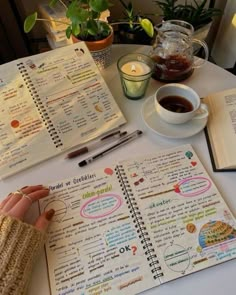 a table with a cup of coffee and an open notebook