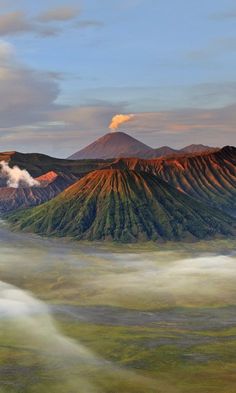 an aerial view of mountains and clouds in the sky