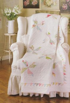 a white chair with a quilt on it