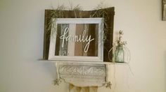 an old window frame with the word family on it is hung above a mantle in a bathroom