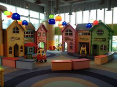 children's play area with brightly colored buildings and toys on the floor in front of windows