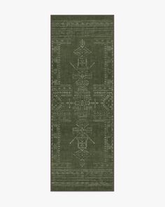 a green rug with an intricate design on the front and back side, in two different colors