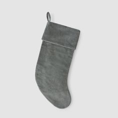 a gray christmas stocking hanging on a white wall