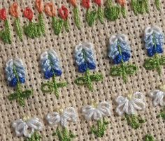 several different types of flowers on a piece of cloth that is stitched together and placed next to each other