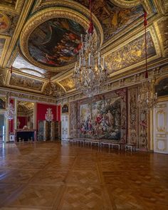 an ornate room with paintings and chandeliers