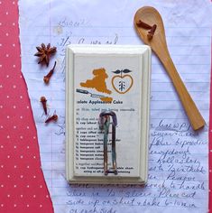 an apple cider is sitting on top of a piece of paper next to a wooden spoon