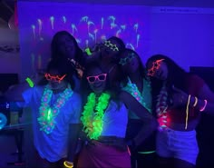 four girls in neon clothing with their arms around each other and one girl wearing glasses