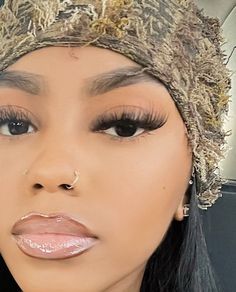 a close up of a person wearing a hat and eyeliner with makeup on her face