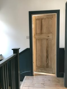 an empty room with a wooden door and railing