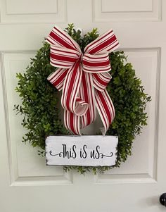 a red and white wreath with a sign that says, this is us