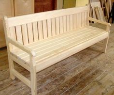 a wooden bench sitting on top of a hard wood floor next to a wall mounted mirror