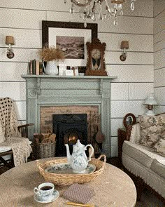 a living room filled with furniture and a fire place under a chandelier hanging from the ceiling