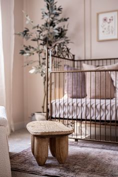 a wooden table sitting in front of a crib with a plant on top of it