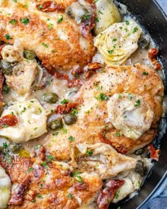 chicken and artichokes in a skillet with parmesan cheese sauce