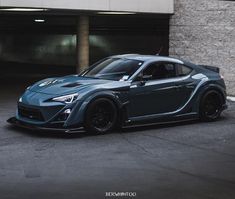 a blue sports car parked in front of a building