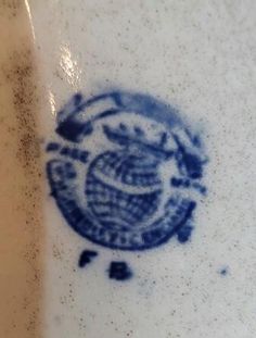 a blue and white plate with an image of a bird on it's side