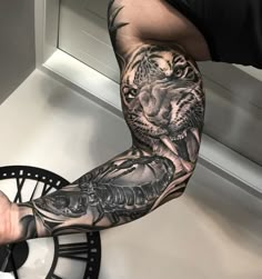 a man's arm with a tiger tattoo on it and a clock in the background