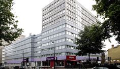 an office building on the corner of a street with cars parked in front of it