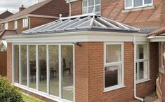 an orange brick house with a glass roof