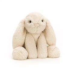 a white stuffed rabbit sitting on the ground