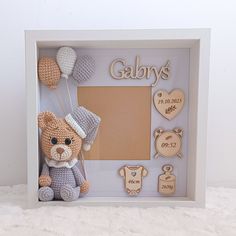 a teddy bear in a frame with baby's items