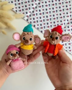 there are three small crocheted mice in the palm of someone's hand