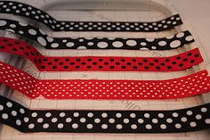 four black and white polka dot ribbon on a cutting board with red tape in the middle