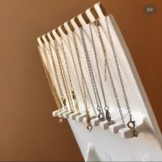 five different necklaces are hanging on a rack