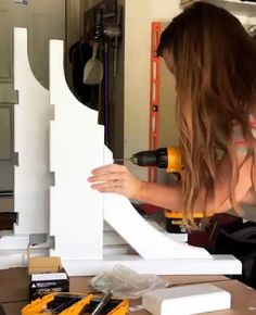 a woman is working on a piece of furniture with tools in front of her,