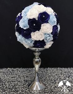 a silver vase with blue and white flowers on it