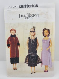 the doll is wearing a dress and hat with two other dolls standing next to each other