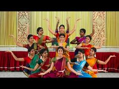 a group of women in colorful saris posing for a photo with their hands up