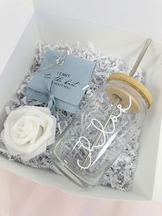 a glass bottle with a wooden lid and a white rose in a gift box that says, i can't wait for you