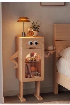 a wooden bed with a lamp on top of it next to a night stand that has a birdcage in front of it