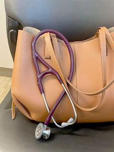 a purse with a stethoscope in it sitting on top of a chair