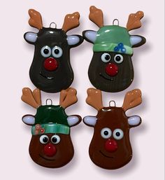 three reindeer head magnets with one wearing a green hat and the other red nose