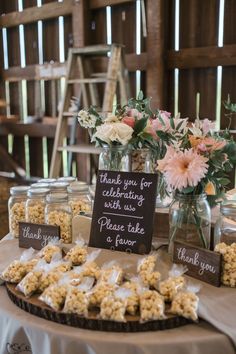 a table topped with jars filled with cookies and flowers next to a chalkboard sign that says thank you for celebrating when we please take a